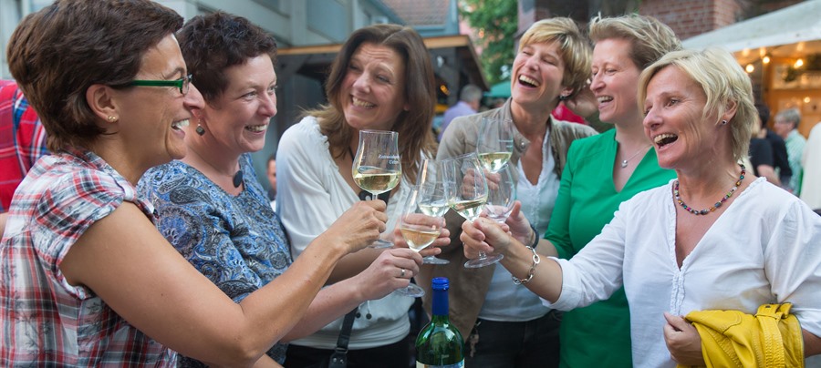 Foto von sechs Frauen, die fröhlich mit Weingläsern auf dem Weinmarkt in Uelzen anstoßen