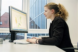 Eine Bauzeichnerin bei der Arbeit am Computer in ihrem Büro
