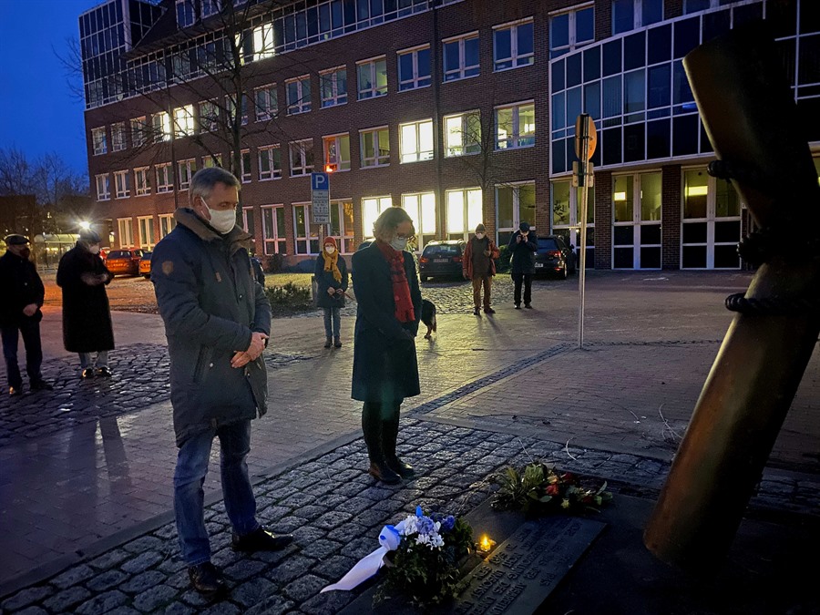 Bürgermeister Jürgen Markwardt, Stadtarchivarin Christine Böttcher und Vertreter der Geschichtswerkstatt legen Blumen am Mahnmal vor dem Rathaus nieder.