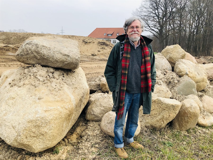 Stadtarchäologe Dr. Fred Mahler neben mehreren Findlingen auf der Baustelle des Gewerbegebietes „Störtenbütteler Weg Nord“