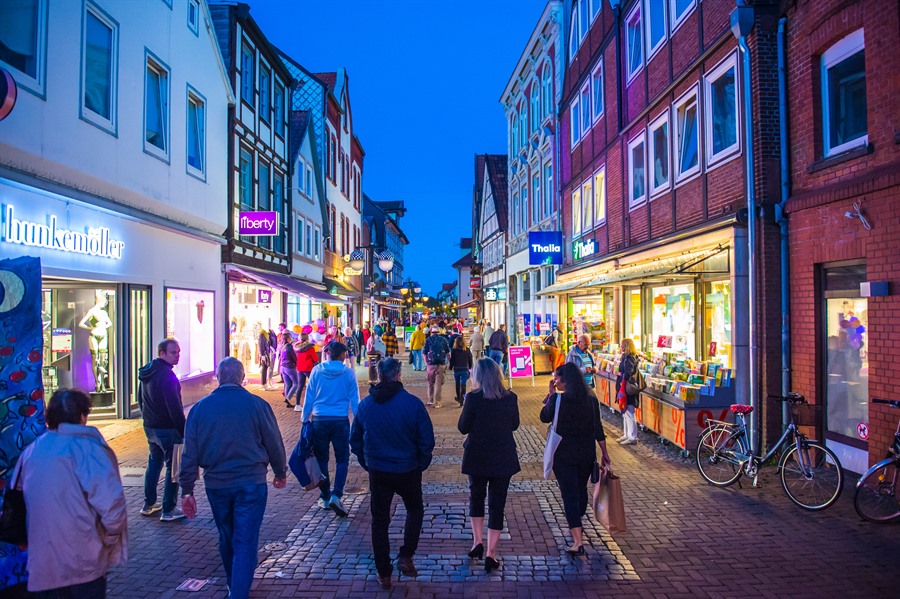 Menschen beim Einkaufen in der beleuchteten Fußgängerzone in Uelzen